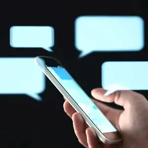 Seller කෙනෙකුට message කරන buyer කෙනෙක්, phone එක වටේට chat bubbles